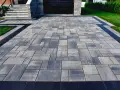 Nowoczesna ścieżka z kostki brukowej w odcieniach szarości. Idealne rozwiązanie, czym wypełnić szczeliny w kostce brukowej, by uzyskać estetyczny wygląd.