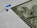 Płytki ceramiczne układane na kleju, widoczne kliny dystansowe i precyzyjnie określona szerokość fugi.