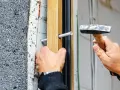 Montaż okna, wbijanie kołka rozporowego w drewnianą ramę. Właściwe kołki do karton-gipsu zapewnią stabilność.