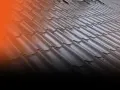 Faliste pokrycie dachowe z ciemnego metalu, prezentujące różne rodzaje farb do metalu.