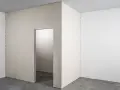 Niedokończona ścianka działowa z płyty meblowej tworzy nowy korytarz.