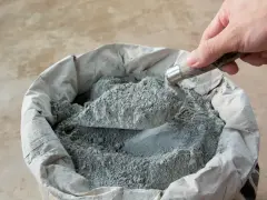 Łopata nabiera suchy beton pod obrzeża. Właściwe proporcje to klucz do trwałej budowy.